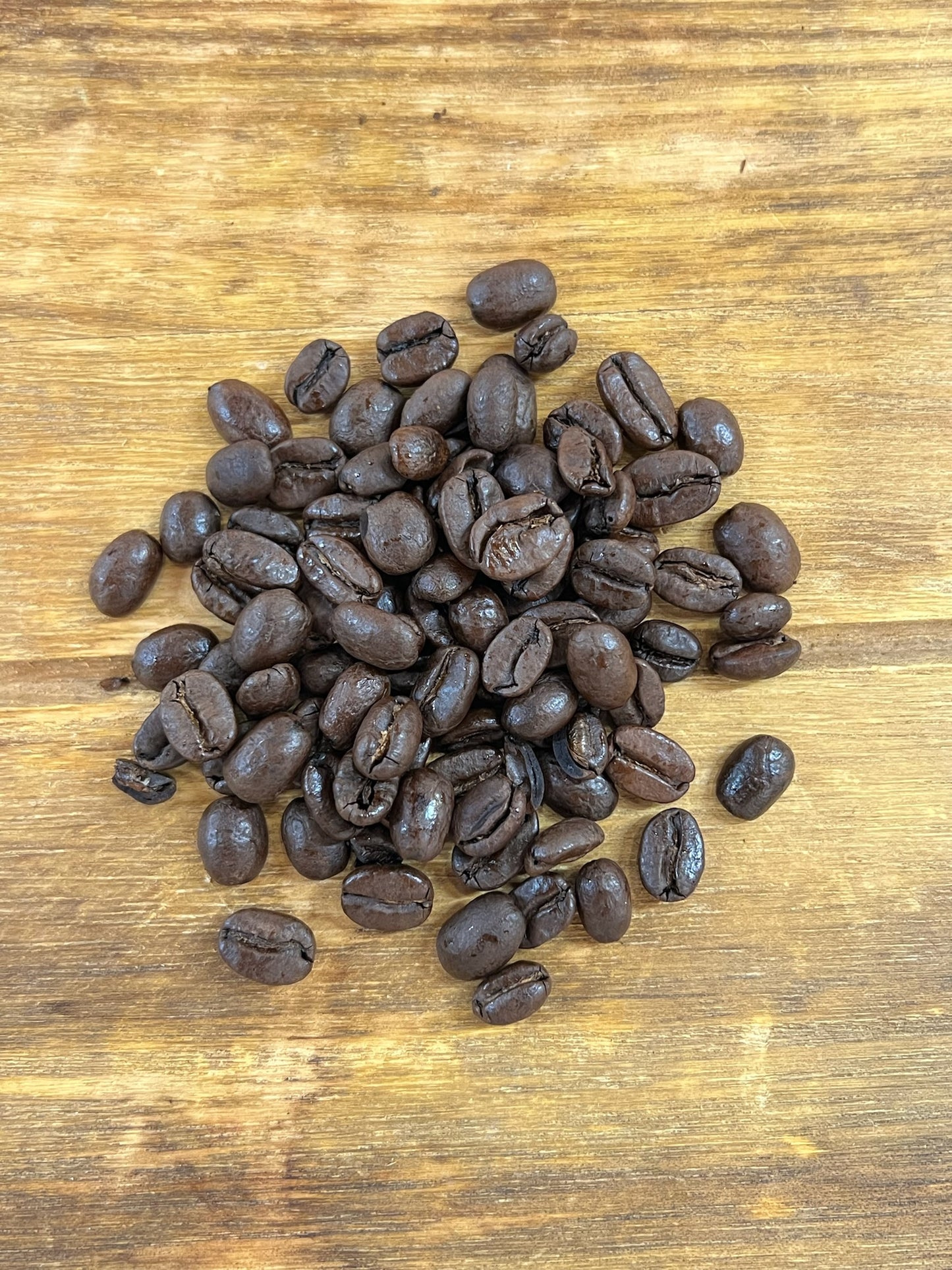 Kaffebönor i hög - Colombia Hulia. Liggandes på en träbricka