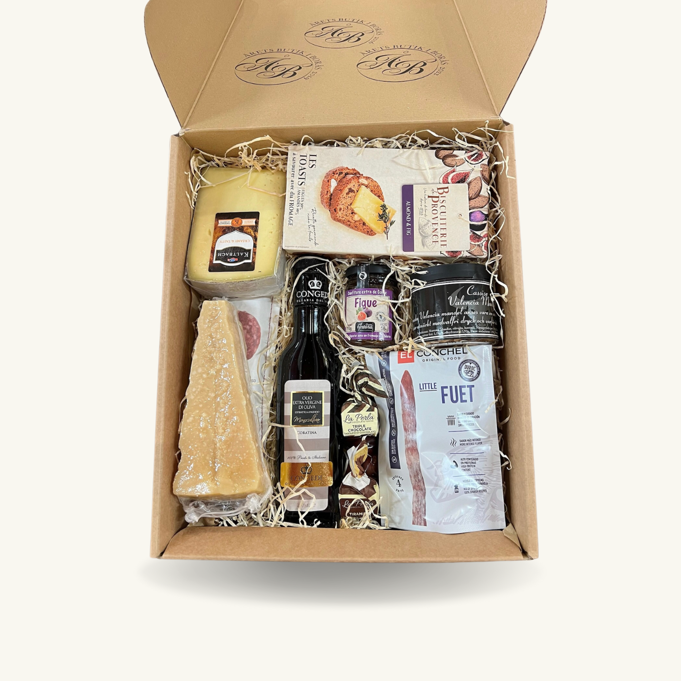Presentbox, gåva, fylld med olika delikatesser så som olika typer av ostar, charkuterier, olivolja, kex med mera.