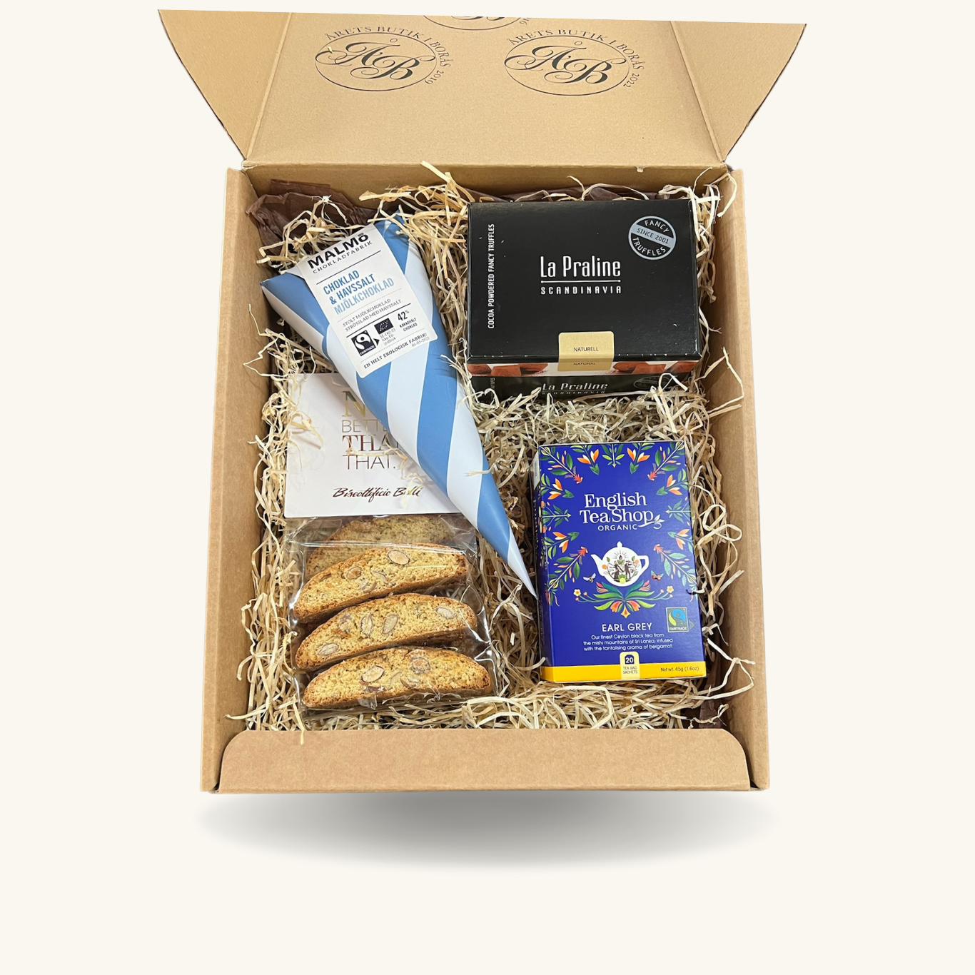 En presentbox fylld med en pralinask, malmöstrut, italienska cantucciniskorpor och English teashop te.